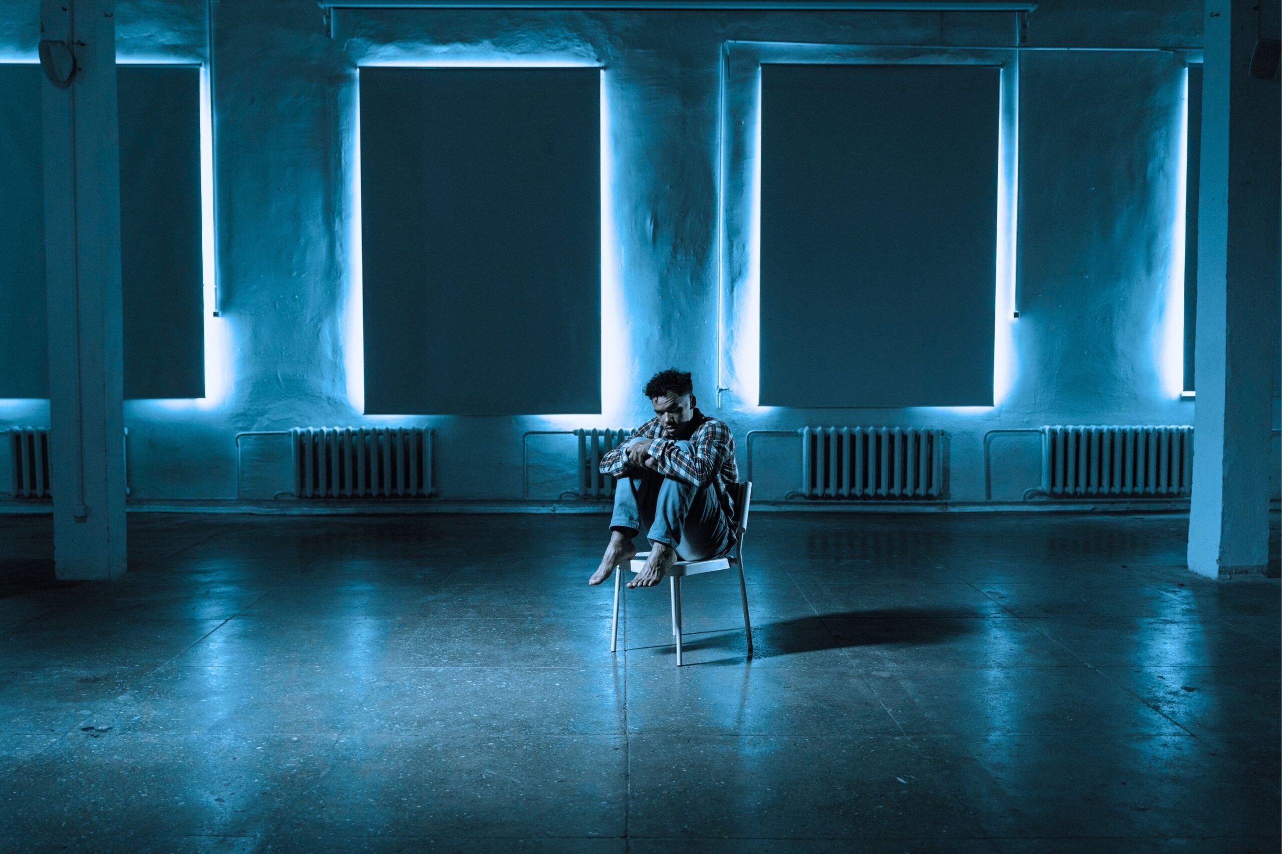 A Frightened Man Sitting Alone on a Chair, wondering how to stop overthinking