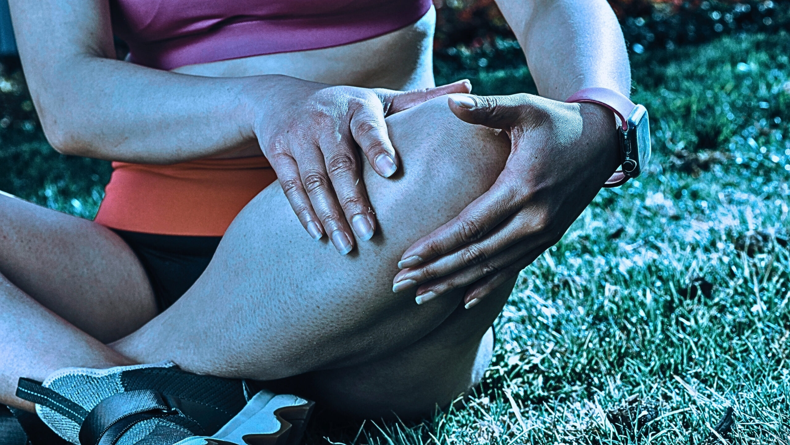 Close-up of Woman Sitting, Managing Pain While Holding Knees