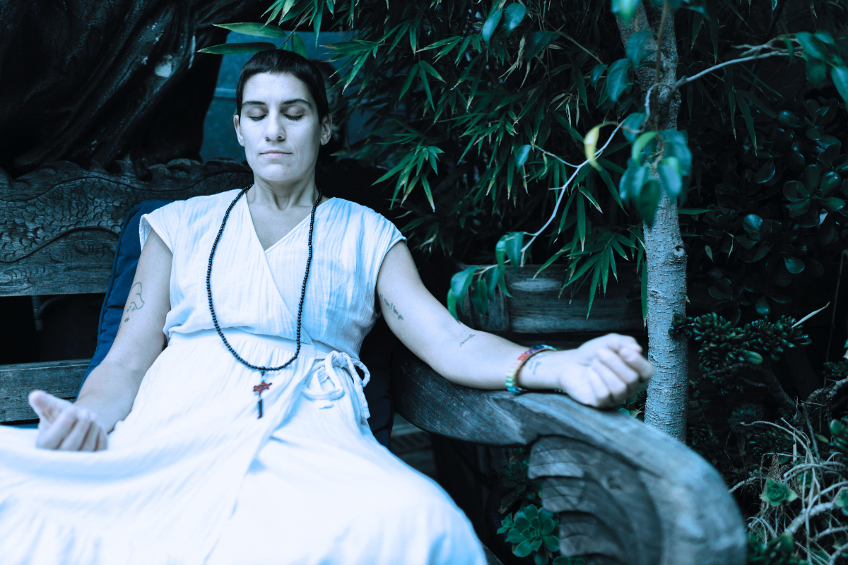 A Woman in White Sleeveless Dress Sitting on Wooden Bench (meditation research)